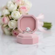 Diamond ring in a pink box with flowers in the background