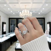 Hand wearing a diamond ring in a jewelry store setting