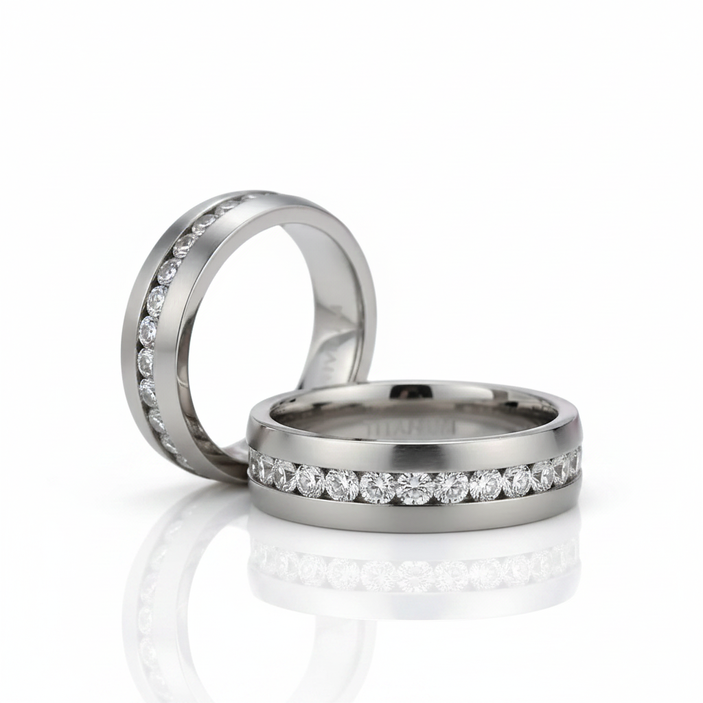 Two polished silver-toned wedding bands with rows of clear round-cut stones, photographed on a clean white reflective surface.