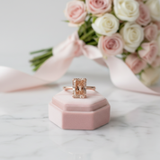 Rose gold ring in a pink box with flowers in the background