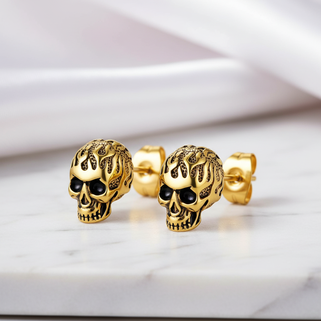 Gold skull earrings on a marble surface