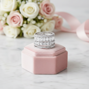 Silver ring with diamonds on a pink jewelry box with flowers in the background