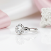 Silver ring with a large diamond on a soft pink background