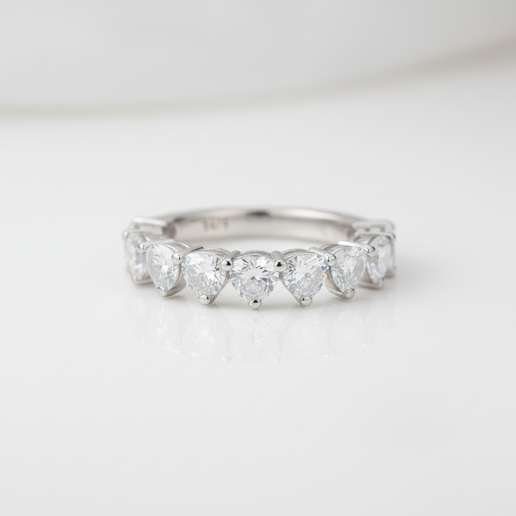 Silver ring with heart-shaped gemstones on a light gray background