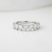 Silver ring with heart-shaped gemstones on a light gray background