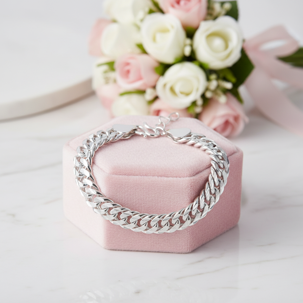 Silver chain bracelet on a pink velvet box with flowers in the background