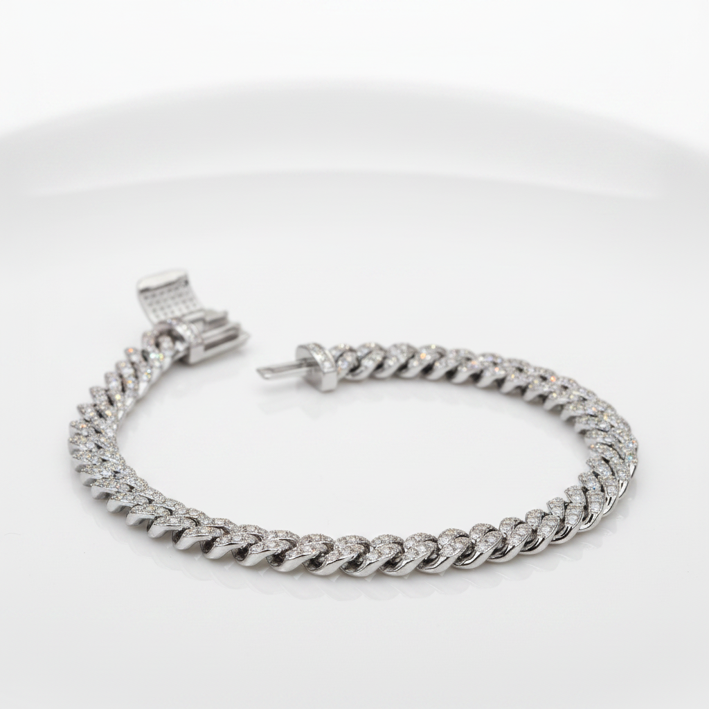 A silver-toned Cuban link chain bracelet paved with small clear stones, displayed on a clean white background.