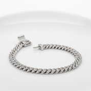 A silver-toned Cuban link chain bracelet paved with small clear stones, displayed on a clean white background.