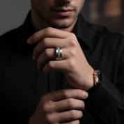 Man wearing a silver ring on his finger with a blurred background