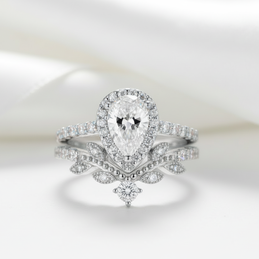 Diamond ring with a pear-shaped center stone on a light background