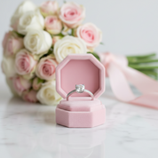 Diamond ring in a pink box with flowers in the background