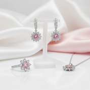 Jewelry set with pink gemstones and silver accents on a soft fabric background