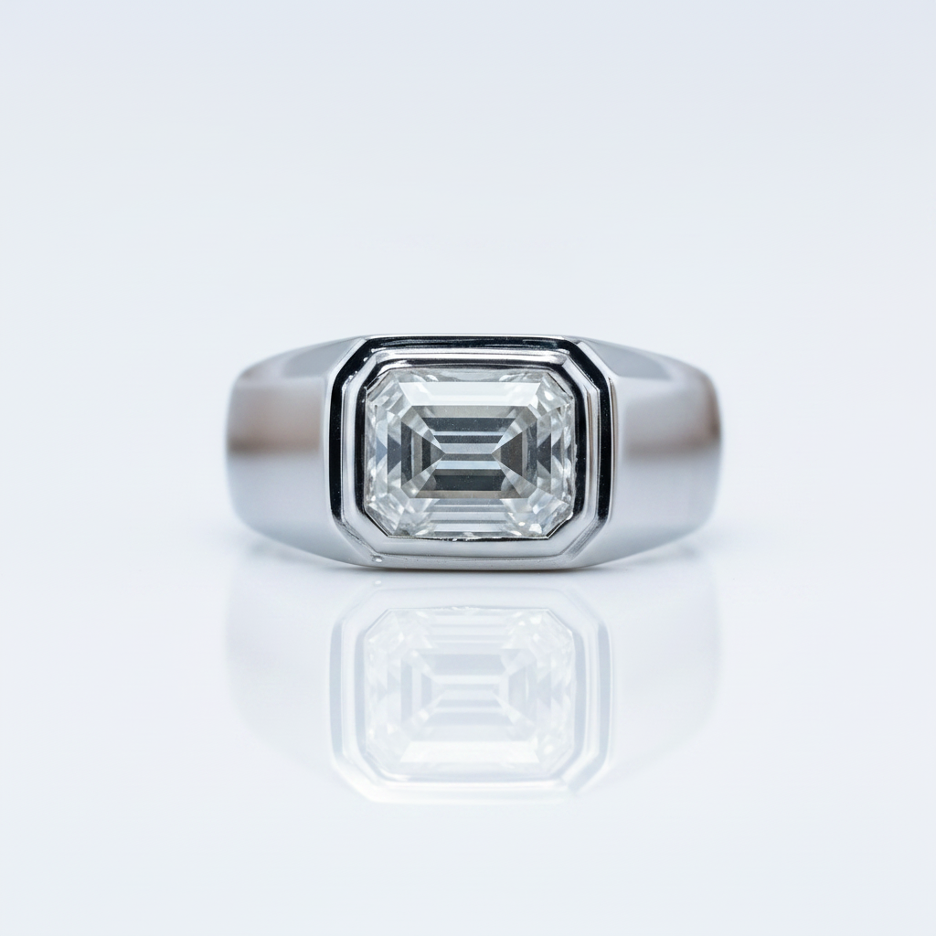A silver-toned signet ring featuring a large emerald-cut clear gemstone, shown on a clean white reflective surface.