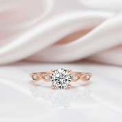 Rose gold ring with a diamond on a soft pink fabric background