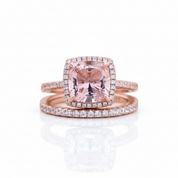 Rose gold ring set featuring a cushion-cut pink gemstone surrounded by a halo of small clear stones, with a matching rose gold band set with clear stones, on a white background with a soft reflection.