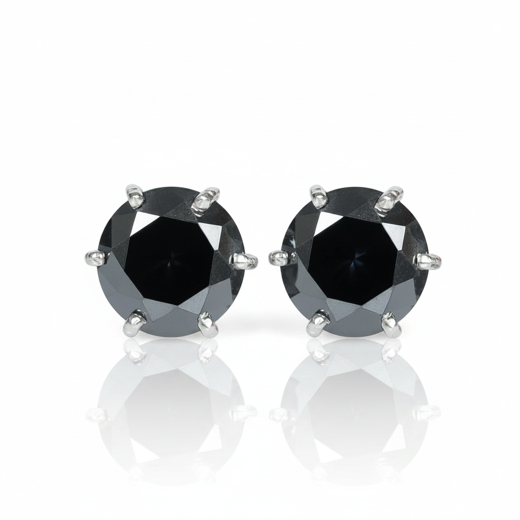 A pair of round-cut black gemstone stud earrings in a silver-toned prong setting, displayed on a clean white background with a soft reflection below.