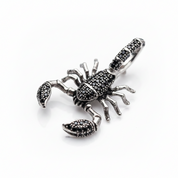A silver-toned scorpion pendant embellished with small black stones by Black Diamonds New York