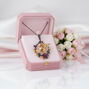 Necklace with floral design in a pink jewelry box on a white background