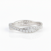 A silver-tone wavy band ring paved with round clear gemstones, shown on a clean white background with a soft reflection.