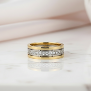 Gold and silver ring with diamond accents on a light background