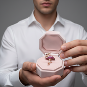 Person holding a pink jewelry box with a key-shaped pendant