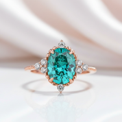 Ring with a green gemstone and rose gold band on a soft background