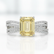 Ring with a yellow gemstone and diamond-studded band on a white background
