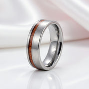 Titanium ring with wooden inlay on a white background