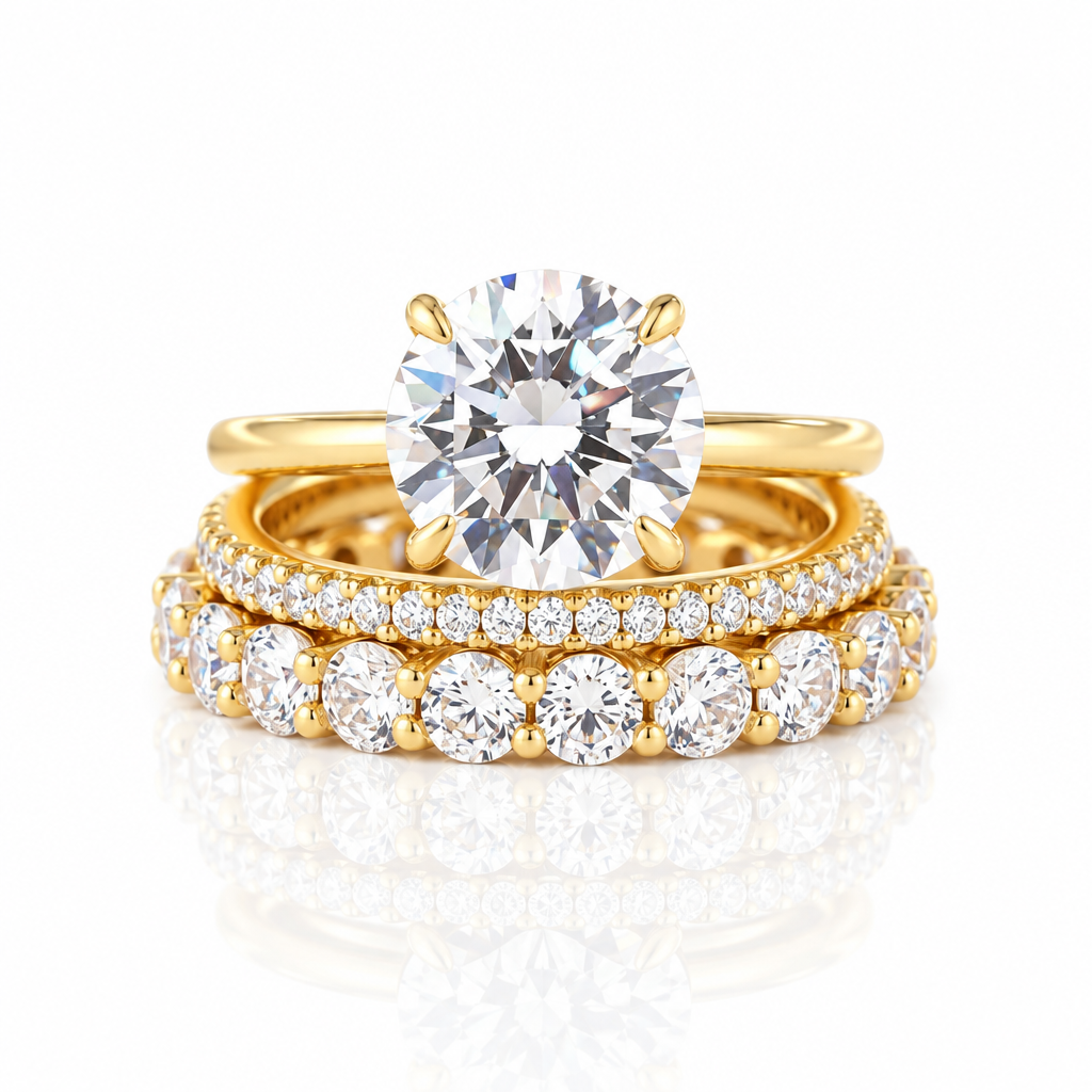 A gold engagement ring with a large round brilliant-cut diamond is displayed with two matching gold wedding bands featuring rows of smaller diamonds on a clean white background with a soft reflection.